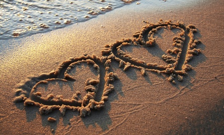 carte 2 cœurs dessinés sur le sable 